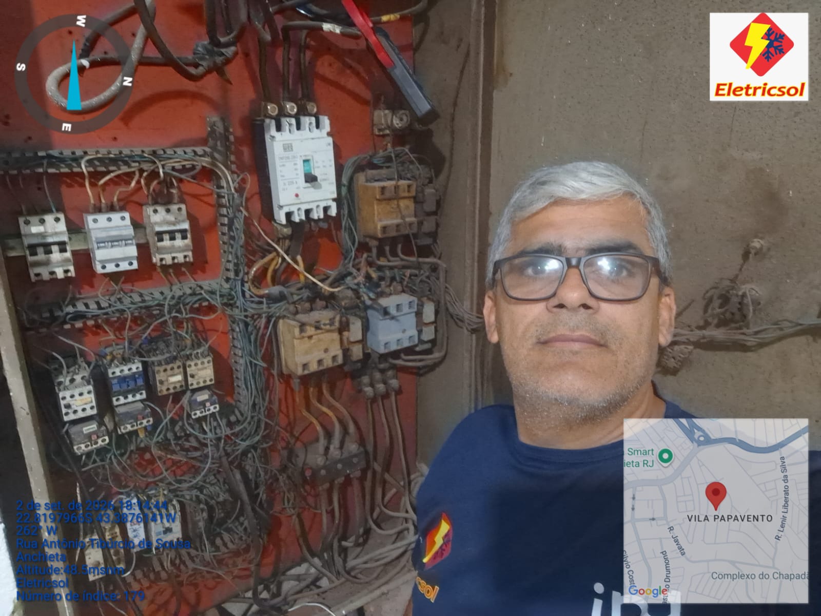 Eletricista em frente a painel elétrico com fiação complexa em serviço de campo